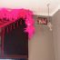 A room with pink feathers and a black curtain