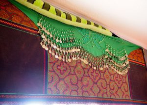A green scarf hanging from the ceiling of a room.