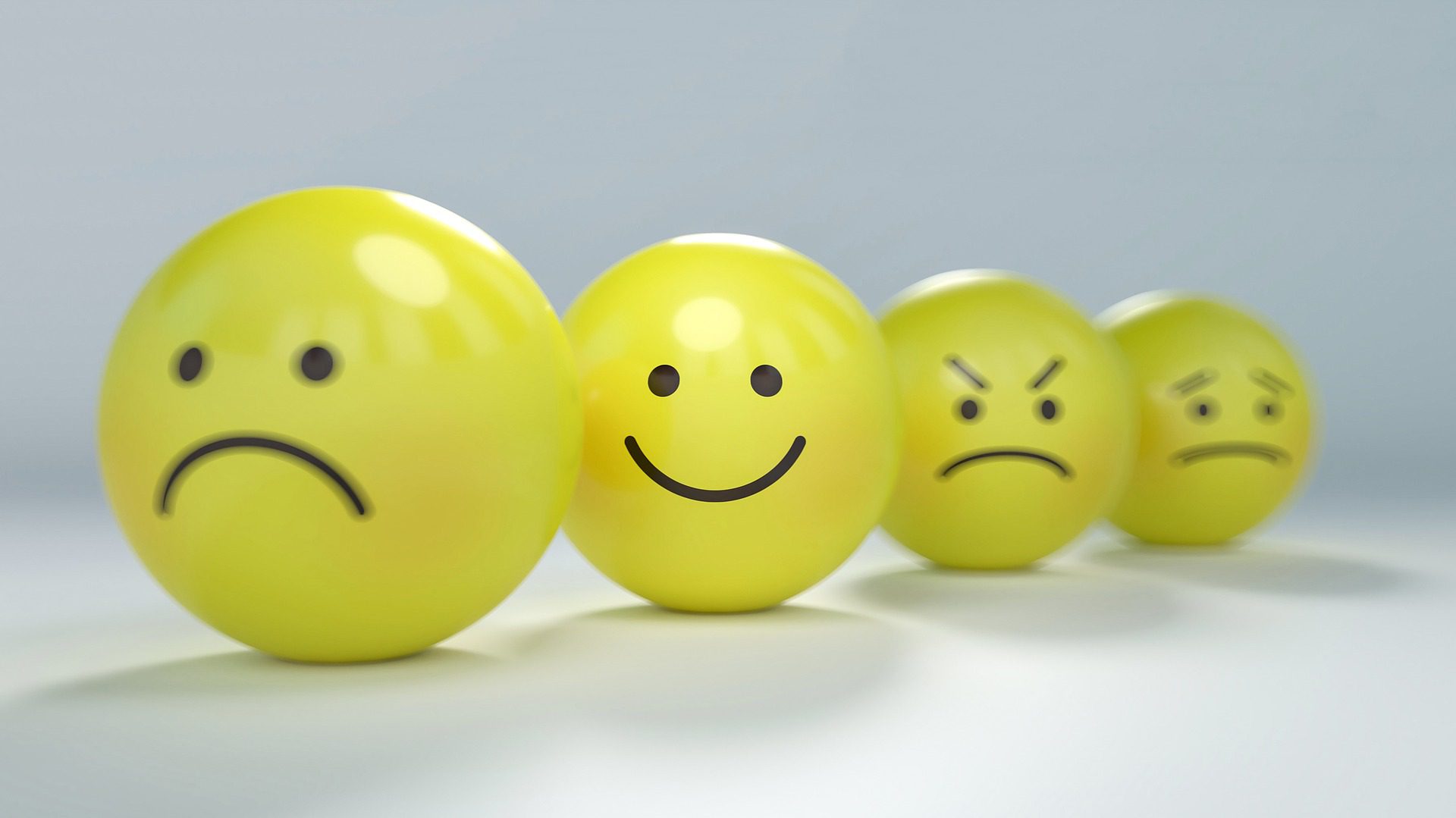 A row of yellow balls with faces drawn on them.